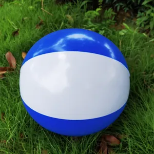 Close-up of a blue and white inflatable beach ball resting on green grass outdoors.