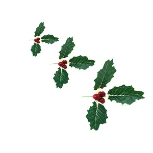 Detailed view of three artificial holly leaf clusters with glossy red berries