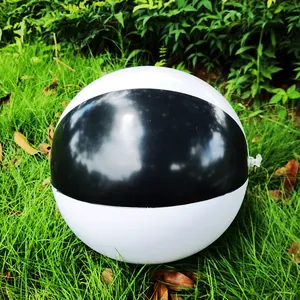 Macro detail of a 36cm black and white inflatable beach ball placed on green grass