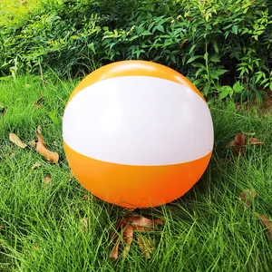 Orange and white inflatable 36cm beach ball resting on green grass outdoors in daylight