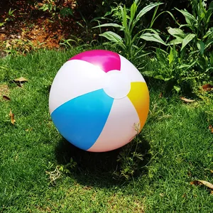 Macro view of a 36cm colorful inflatable beach ball resting on fresh green grass