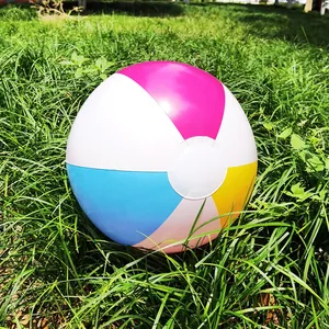 Macro view of a vibrant multi-colored inflatable beach ball on green grass