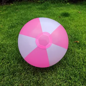 Close-up of a 36cm pink and white inflatable beach ball resting on a green lawn.