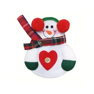 Detail of a festive snowman cutlery holder made of soft non-woven fabric and red plaid