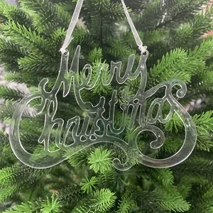 Primer plano de un adorno "Merry Christmas" de acrílico en una rama de pino verde