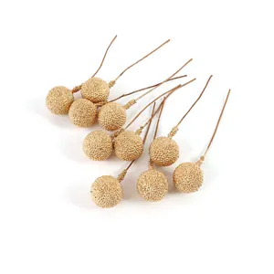 Detail view of golden artificial berries with textured surface for Christmas DIY crafts