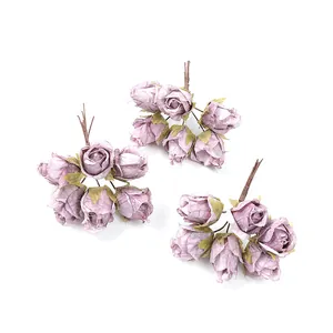 Dettaglio di tre mazzi di rose artificiali viola vintage per decorazioni fai-da-te.