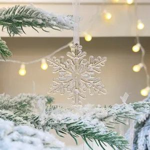 Detailansicht eines klaren Acryl-Schneeflocken-Ornaments an einem Weihnachtsbaum