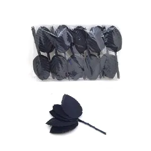 Detailed macro view of black artificial rose leaves with wire stems in bulk plastic packaging.