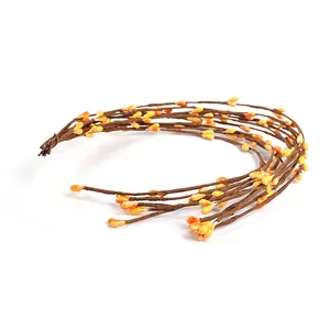 Detailed close-up of yellow artificial berry vines for DIY crafts and home decor.