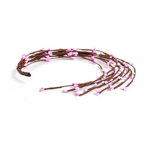 Detail of artificial berry vine branches with realistic pink buds for DIY home decor