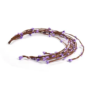 Detailed close-up of artificial brown twig vine with glossy purple berries for DIY crafts