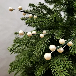 Gros plan de branches de Noël décoratives avec des perles crème sur des aiguilles de pin