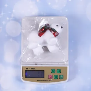 Macro view of a fuzzy white Christmas polar bear ornament featuring a festive red bow.