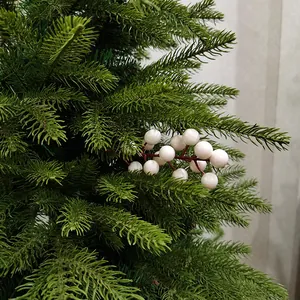 Close-up van kunstmatige witte kerstbessen op weelderige groene dennennaalden