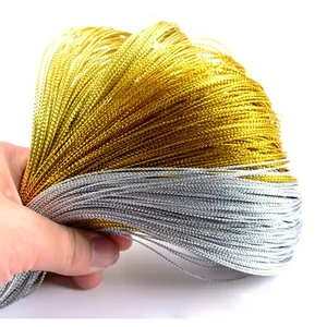 Close-up of gold and silver metallic gift wrapping cords showing detailed woven texture