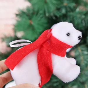 Detailed close-up view of a fuzzy white polar bear Christmas ornament with a red scarf