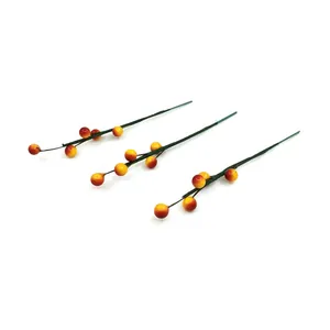 Détail de tiges de baies de Noël artificielles dégradées rouge et jaune pour déco DIY