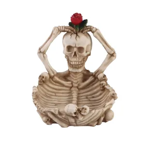 Vista dettagliata del posacenere a forma di teschio in resina con decorazione rosa rossa
