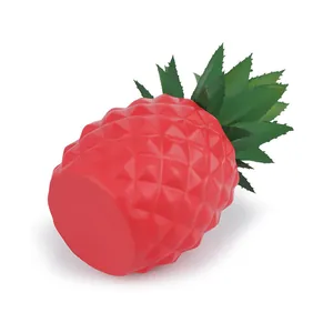 Detail of a red resin pineapple ornament with green synthetic leaves for desk decor