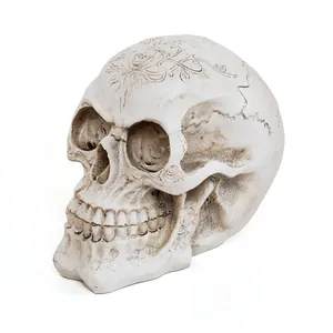 Detailed macro view of a white resin skull decoration with intricate floral carvings