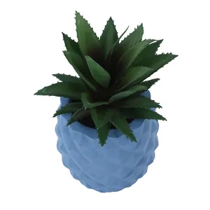 Close-up view of a green faux succulent in a blue pineapple-shaped resin pot ornament