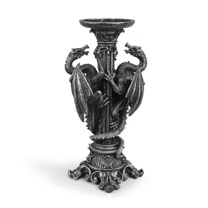 Detalle de candelabro gótico de resina con dos dragones y textura metálica intrincada.