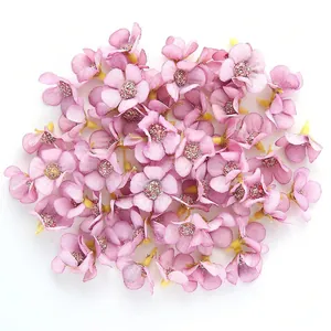 Dettaglio di mini teste di margherita in seta rosa da 2 cm con centro glitterato