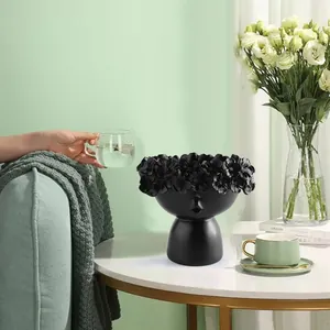 Nordic creative face art flower pot in matte black placed on a modern coffee table