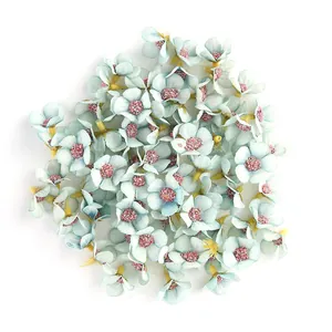 Dettaglio di mini teste di margherita artificiali in seta blu da 2cm con glitter rosa