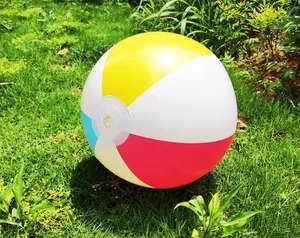 Close-up detail of a 40cm colorful inflatable beach ball resting on green grass