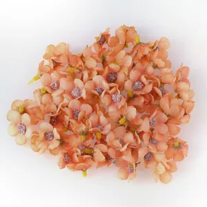 Dettaglio ravvicinato di mini teste di margherita in seta arancione per decorazioni
