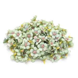Vista dettagliata di più mini teste di fiori di margherita verde artificiale da 2cm