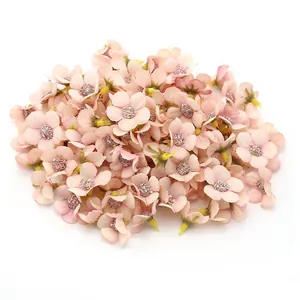 Dettaglio di mini teste di margherite in seta rosa da 2 cm per decorazioni fai da te