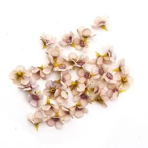Dettaglio macro di mini teste di margherite in seta rosa cipria 2cm per matrimoni