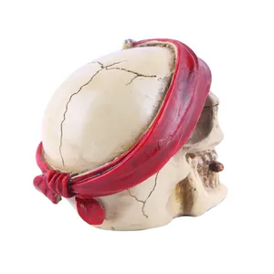 Detalle de figura de calavera pirata de resina con diadema roja para Halloween