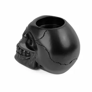 Detailed side view of a matte black resin skull ashtray for Halloween home decor