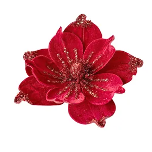 Détail d'une fleur de magnolia en velours rouge avec des paillettes dorées