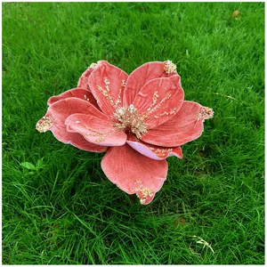 Détail d'une fleur de magnolia artificielle en velours rose avec des paillettes.