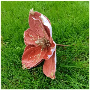 Gros plan d'une fleur de magnolia artificielle en velours terre cuite sur l'herbe