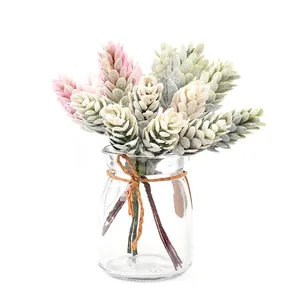 Detail of artificial frosted pine cone bouquet in glass vase for cozy home decoration