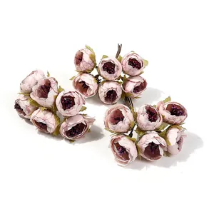 Vista dettagliata di mini bouquet di fiori artificiali rosa per ghirlande fai-da-te e hobby.