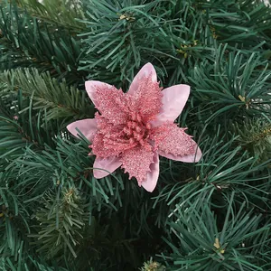 Detailed close-up of a pink glittery artificial Christmas flower on green pine branches