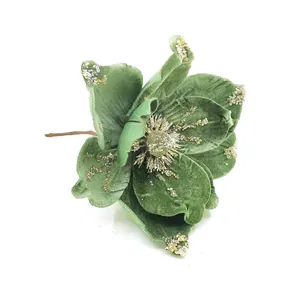 Détail d'une fleur de magnolia de Noël artificielle en velours vert pailleté.