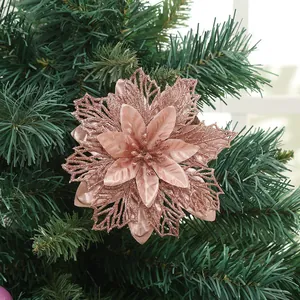 Fiore di stella di Natale artificiale oro rosa scintillante su ramo di albero di Natale.