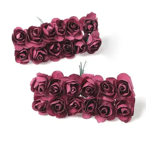 Nahaufnahme von dunkelroten Mini-Papierrosen für die Dekoration von Hochzeitsboxen.