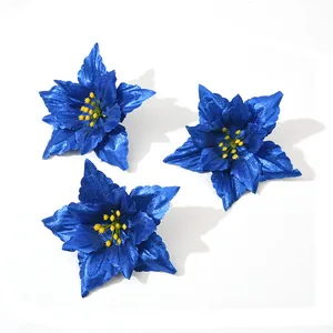 Close-up detail of three vibrant blue artificial poinsettia flowers for holiday decor