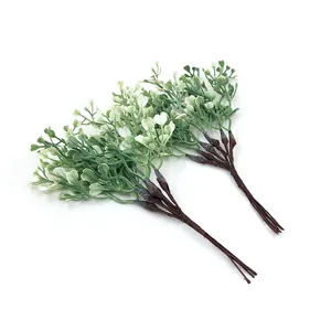 Detailed view of two bundles of artificial green heart-leaf plastic plant stems for DIY decor