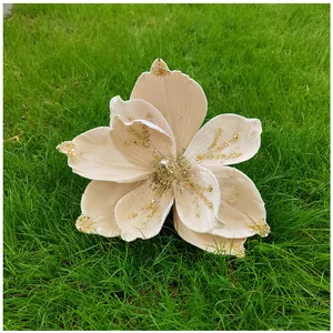 Gros plan d'une fleur de magnolia artificielle avec paillettes sur l'herbe