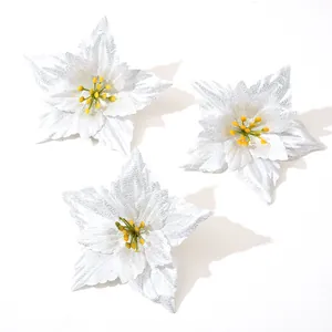 Detailed view of silver artificial poinsettia flowers with yellow stamens for decoration.